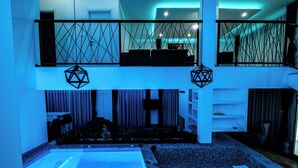 Un interno moderno con zona piscina, un balcone con ringhiera e un’area relax con cuscini.