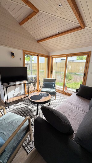 A modern living room with a flat-screen TV, a sofa, a chair, and a table. - Seaside house - 500m from Cap Coz beach - Fouesnant (Fouesnant)