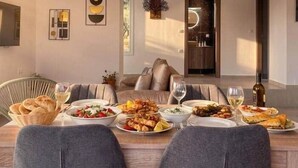 Un comedor con techo de madera, un sofá y una mesa dispuesta con comida y bebidas.
