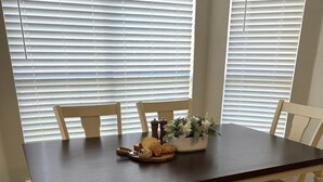 Ett matbord med stolar, en bänk och en blomsterdekoration i mitten.
