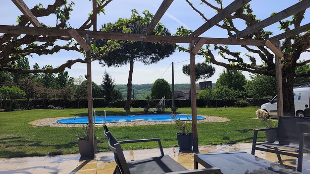 A covered patio with a pool, outdoor furniture, and a view of the surrounding landscape. - Country house (Saint-Sylvestre-sur-Lot)