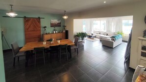 A spacious living area with a dining table, sofa, and large windows. - Country house (Saint-Sylvestre-sur-Lot)