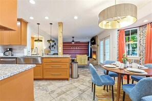 A modern kitchen with granite countertops, wooden cabinets, and a central island. - Elegant Escape • Sleeps 14 • Games, Pool, Fire Pit (San Antonio)