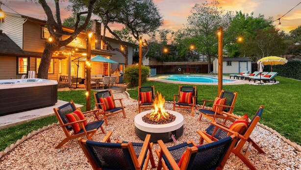 Ein Garten mit Feuerstelle, Sitzgelegenheiten im Freien, Whirlpool und Swimmingpool.