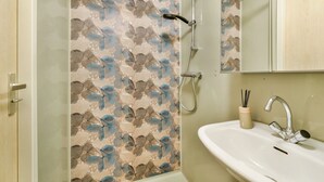 A bathroom with a shower, sink, and mirror.