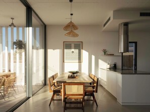 A modern kitchen with a dining area, large windows, and a view of the outdoors. - Modern Elegance Meets the Wild Beauty of Carvalhal (Carvalhal)