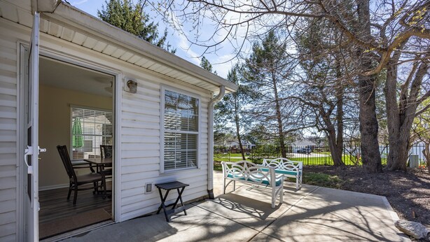 A single-story house with a patio, a table, and chairs. - Keystone Garden Villa G (Indianapolis)