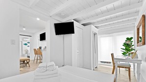 Habitación de hotel moderna con cama, escritorio, televisor y vista al exterior.