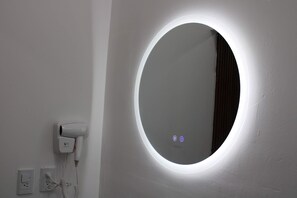A bathroom with a round mirror, a hair dryer, and a power outlet. - Private Room, Zona Consulado (Zapopan)