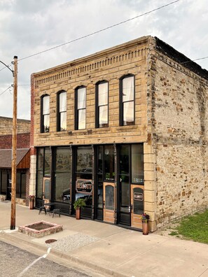 A two-story building with large windows and a brick facade. - Suite A at The Elliott 1887 (LeRoy)