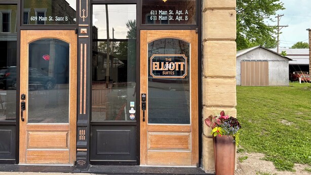 A building with two doors labeled '609 Main St. Suite B' and '611 Main St. Apt. A, 611 Main St. Apt. B'. - Suite A at The Elliott 1887 (LeRoy)