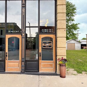 A building with two doors labeled '609 Main St. Suite B' and '611 Main St. Apt. A, 611 Main St. Apt. B'. - Suite A at The Elliott 1887 (LeRoy)