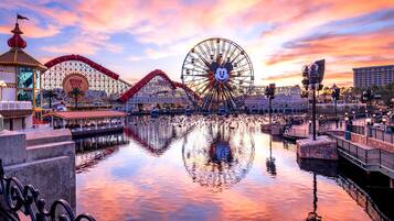 A water body reflecting amusement park rides and structures.