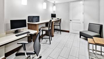 A modern office space with desks, chairs, computers, and a door.