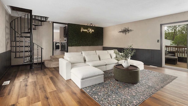A modern living room with a white sofa, a round coffee table, and a staircase. - Great Home_ Sleeps 10_Close to Arrowhead_Football (Independence)