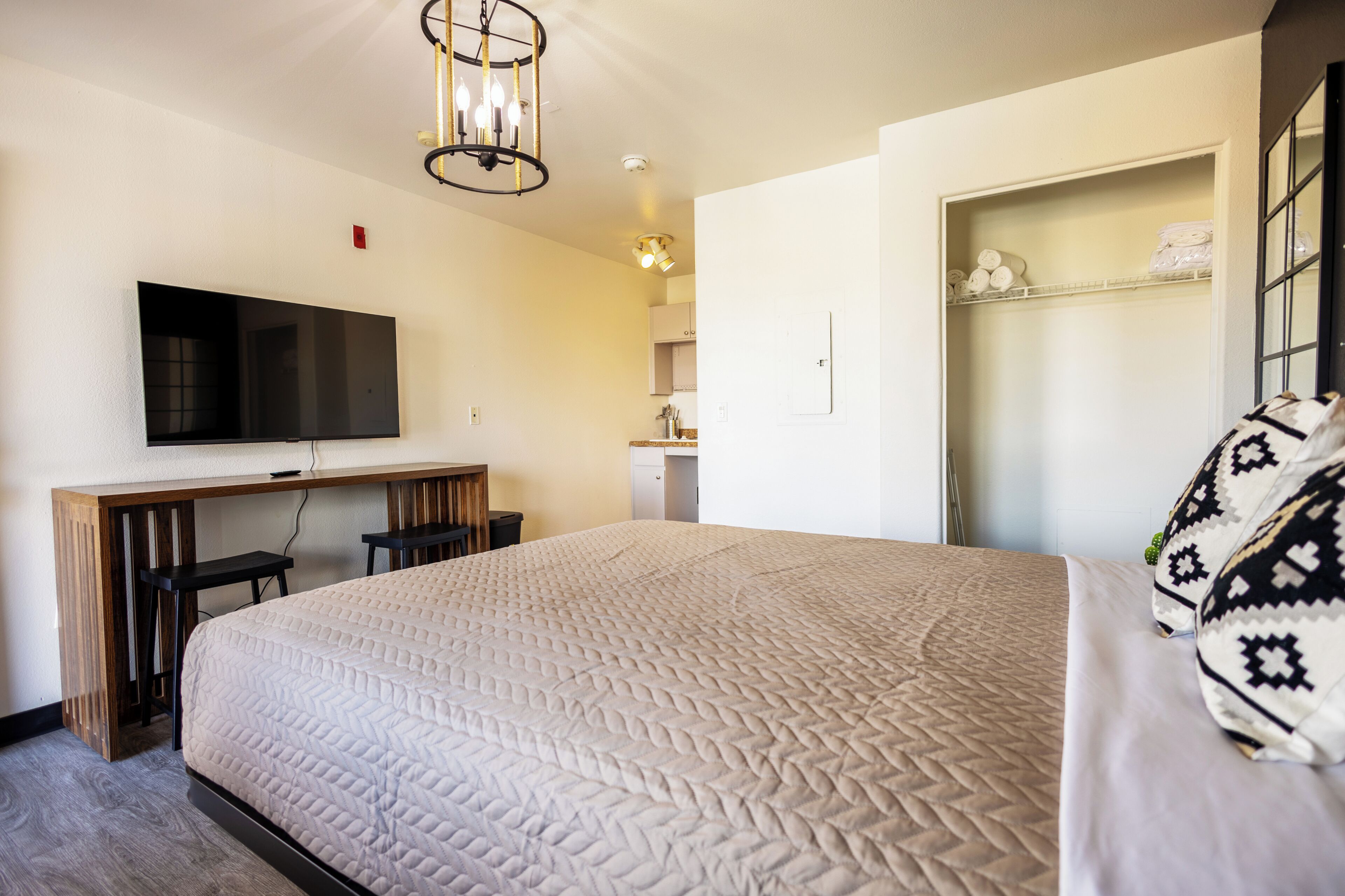 Ett hotellrum med en säng, ett skrivbord, en tv och en garderob.