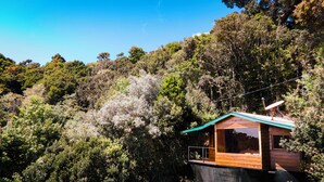 A cabin with a wooden exterior, a balcony, and a satellite dish. - Hotel Gema del Bosque (Copey)