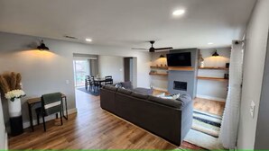 A modern living room with a sofa, dining table, and TV. - Spacious Remodeled Home with Huge Backyard (Denison)