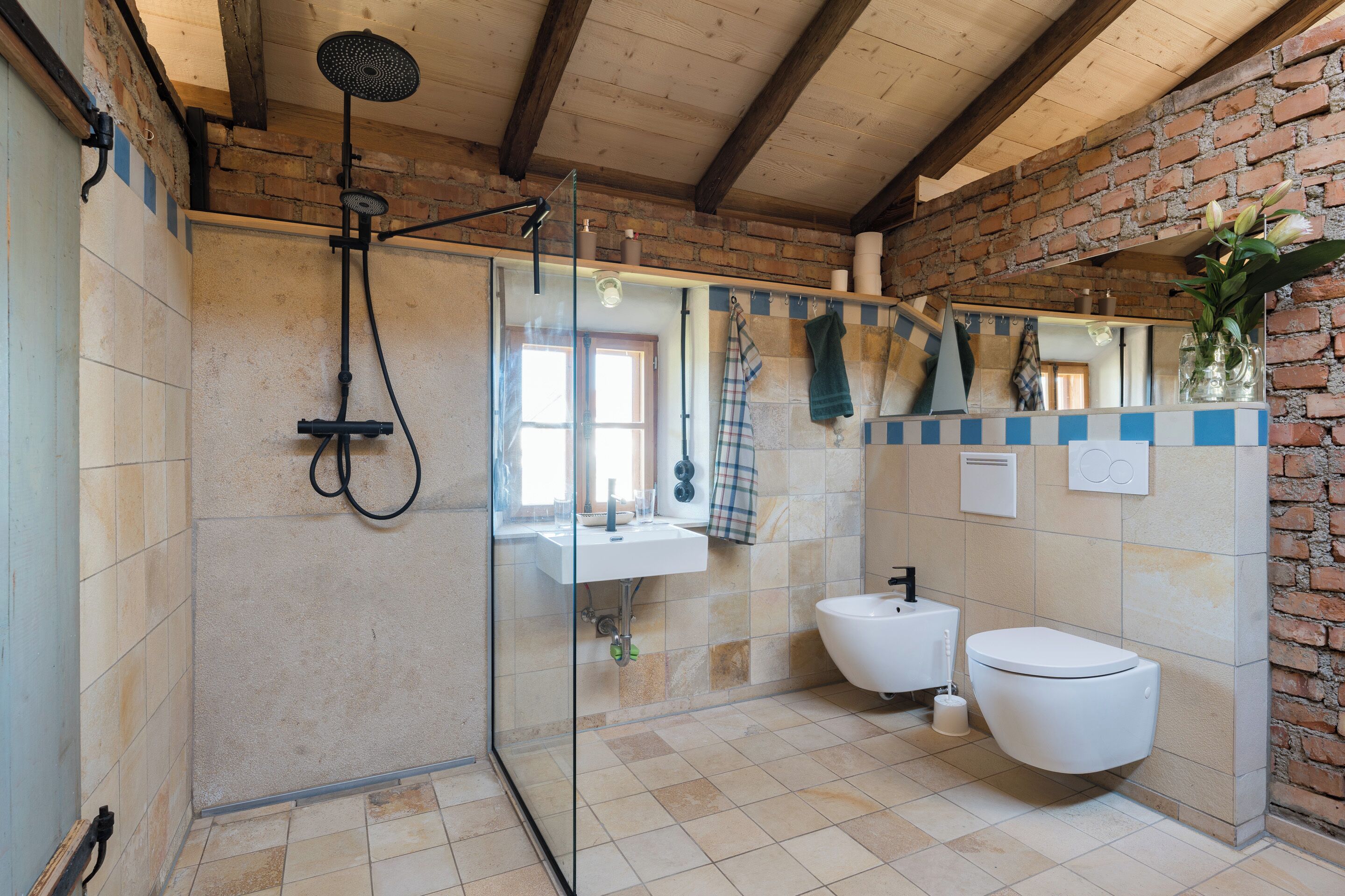 A bathroom with a glass shower enclosure, a sink, a toilet, and a mirror.