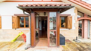 Una casa con techo de tejas, puerta de madera y un pequeño porche.