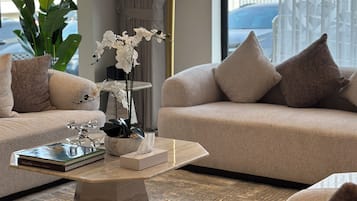 Leilighet – deluxe | Oppholdsområde | En 45-centimeters Flatskjerm-TV med Parabol-TV samt peis