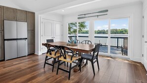 Una cocina con comedor, piso de madera y vista al exterior.