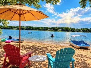 A lakeside beach with kayaks, a covered boat, and beach chairs. - Waterfront + Sunset + Dock Views and Lake Wylie (Charlotte)