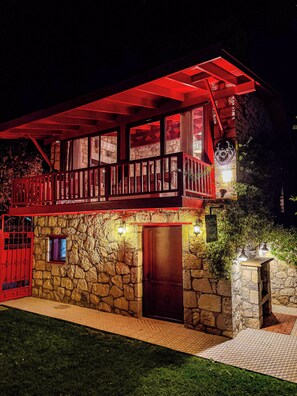 A two-story stone building with a red balcony and a stone entrance. - Casa Del Olivia (Seferihisar)