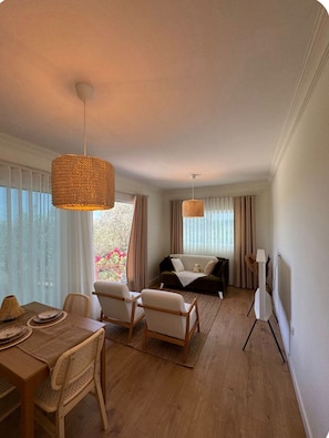 Une chambre d’hôtel comprenant un coin repas, un canapé et un meuble pour la télévision.