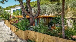 A modern house with a wooden fence, a hammock, and a garden. - Casa Del Olivia (Seferihisar)