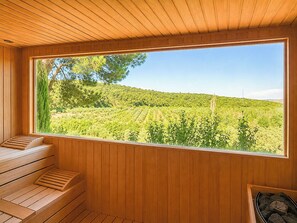A wooden interior with a large window overlooking a vineyard.