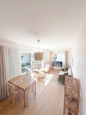 A spacious living area with a dining table, chairs, a sofa, and a TV. - Casa Del Olivia (Seferihisar)