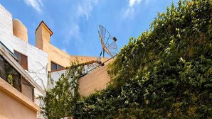 Une terrasse avec une table et des chaises, un hamac et une antenne parabolique.