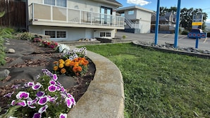Un motel con un letrero, un balcón y un parterre de flores.