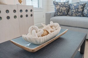 Ein Zimmer mit einer grauen Couch, einem Holzschrank mit runden Aussparungen und einer dekorativen Schale auf einem Tisch.