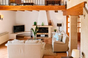 Ein Wohnzimmer mit Kamin, Fernseher und einer Couch.