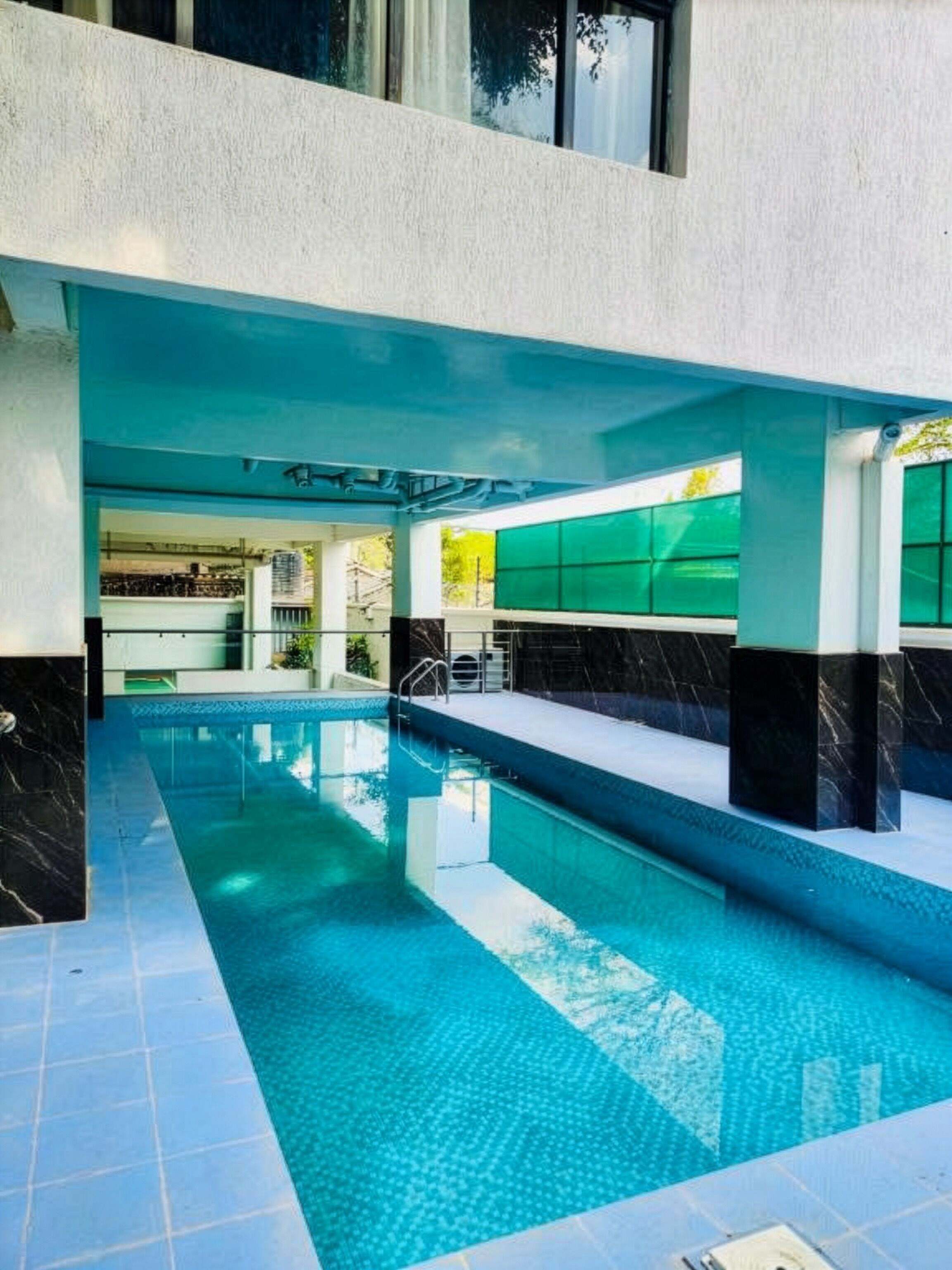 Ein Innenpool mit freiem Blick auf den Poolbereich, gefliestem Boden und modernem architektonischem Design.