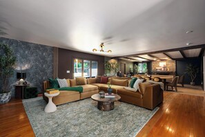 A modern living room with a sectional sofa, a coffee table, and a dining area with chairs.