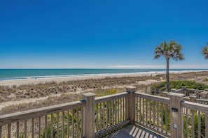 A wooden deck overlooking a beach with a clear sky. - Spacious Home in Ocean Lakes. Outdoor entertainment, and Gated covered deck. (Myrtle Beach)