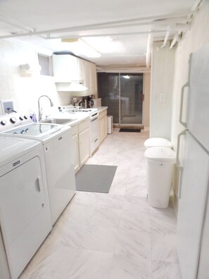 A modern kitchen with white appliances, a dishwasher, and a refrigerator. - TUFTS - Quiet Furnished Apt w/All Included (Medford)