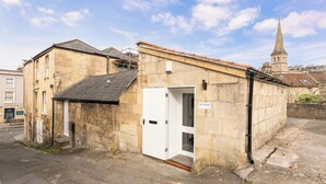 A stone building with a white door, a small entrance, and a sign reading 'THE STUDIO.' - One Bedroom Retreat in Prime Location - Pass the Keys (Bath)