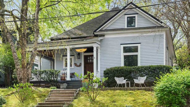 A two-story house with a porch, a front door, and a staircase leading to the entrance. - Georgia Grove (Atlanta)