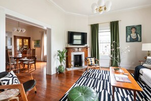 A living room with a fireplace, a television, a dining area, and a sofa. - Georgia Grove (Atlanta)