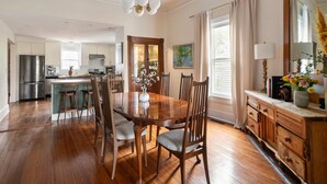 A spacious kitchen with wooden cabinets, a central island, and a dining area with a wooden table and chairs. - Georgia Grove (Atlanta)