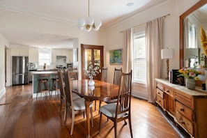 A spacious kitchen with wooden cabinets, a central island, and a dining area with a wooden table and chairs. - Georgia Grove (Atlanta)
