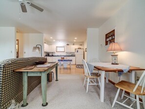 A compact living space with a kitchenette, a dining area with a table and chairs, and a sofa.