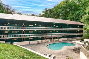 A motel with a pool, two-story structure, and a fenced deck area. - Cozy w/King Bed and Game Room! 5 Min to Parkway (Gatlinburg)