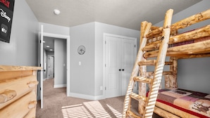 A room with a bunk bed, a wooden ladder, a door, and a wall-mounted clock. - Aspen Tree Chalet |Snowbasin|By Pineview Reservoir (Mountain Green)