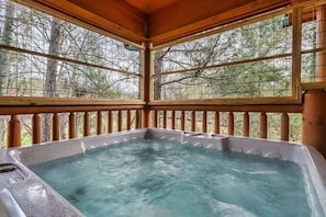 A hot tub with a view of trees through wooden railings. - Hot Tub Hideaway! 5 Min to Parkway | Cozy n Quiet! (Pigeon Forge)
