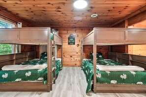 Ein Zimmer mit Etagenbetten, Holzwänden, einer Deckenleuchte und einem Schild an der Wand.
